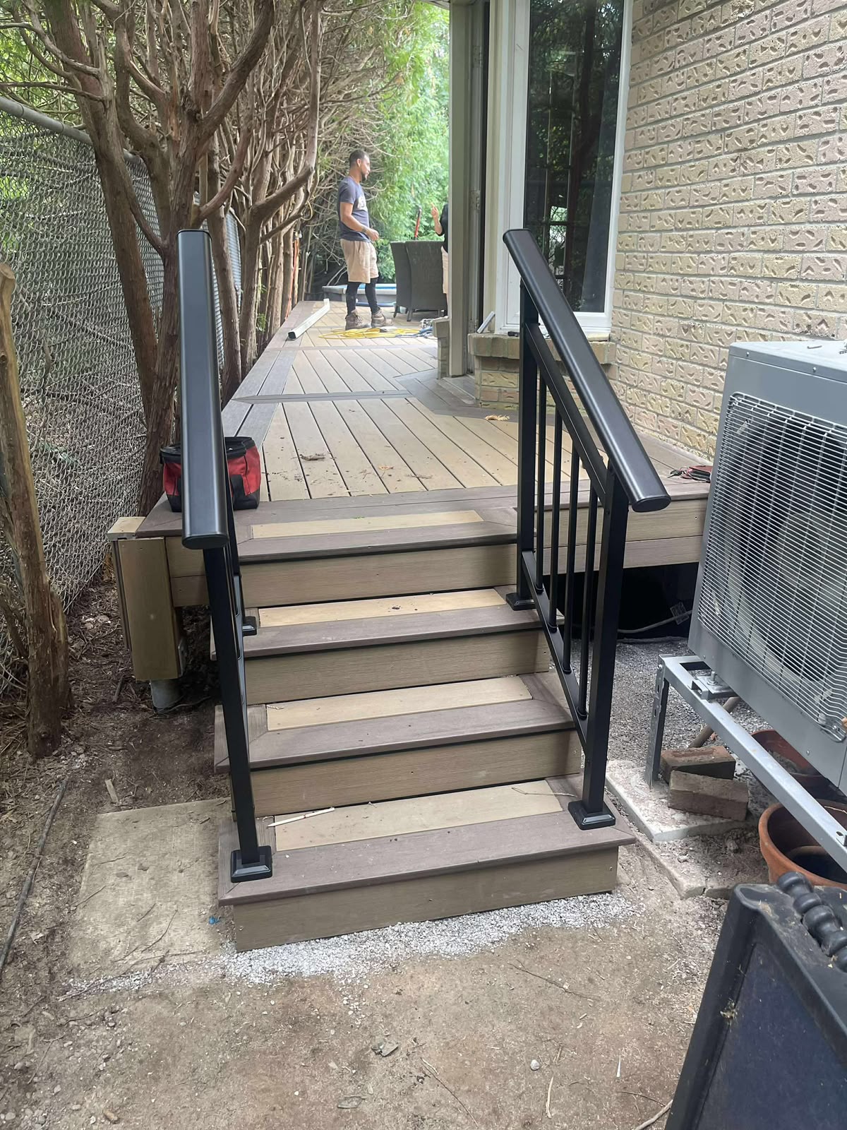 Finished composite stairs with aluminum railings leading to the deck