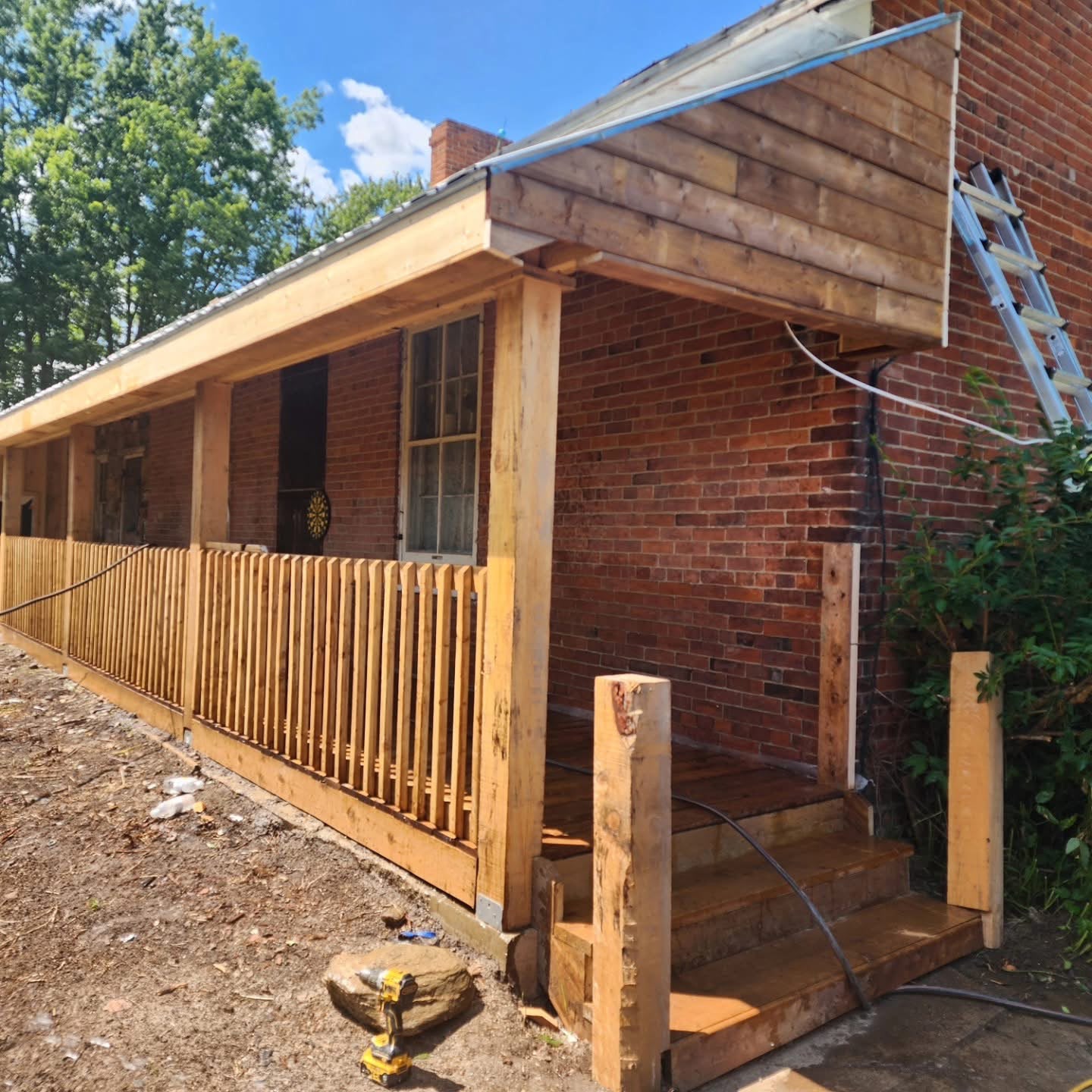 Rebuilt front porch with cedar posts and railings against original brick