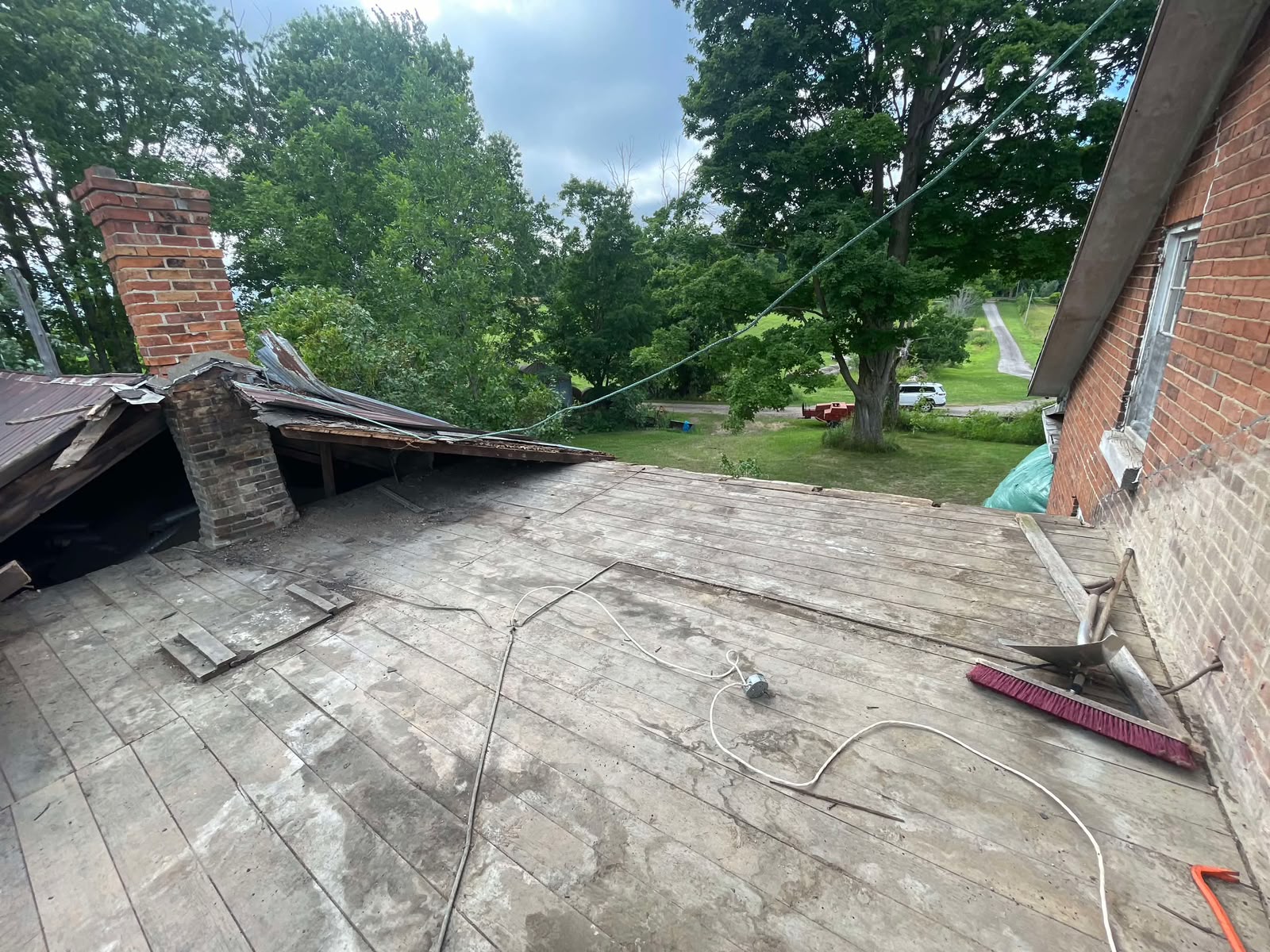 Original roof deck exposed with brick chimney during tear-off