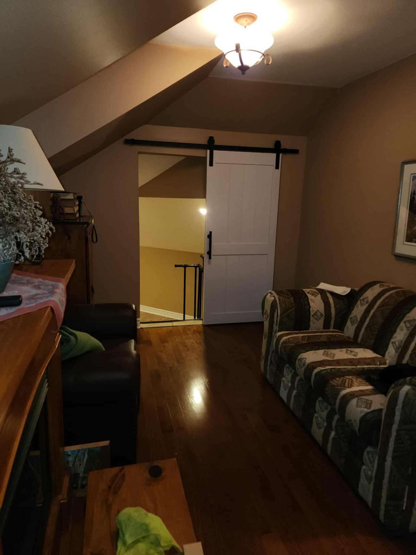 Finished sitting area with sliding barn door leading into the new master suite space
